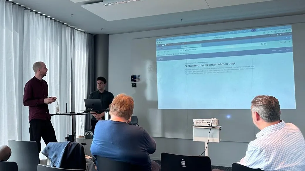 Live Hacking Session von act digital: zwei Referenten am Stehpult, Publikum, Leinwand mit Live-Demo